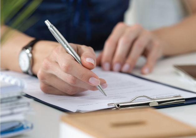 a woman filling out paperwork on a clipboard