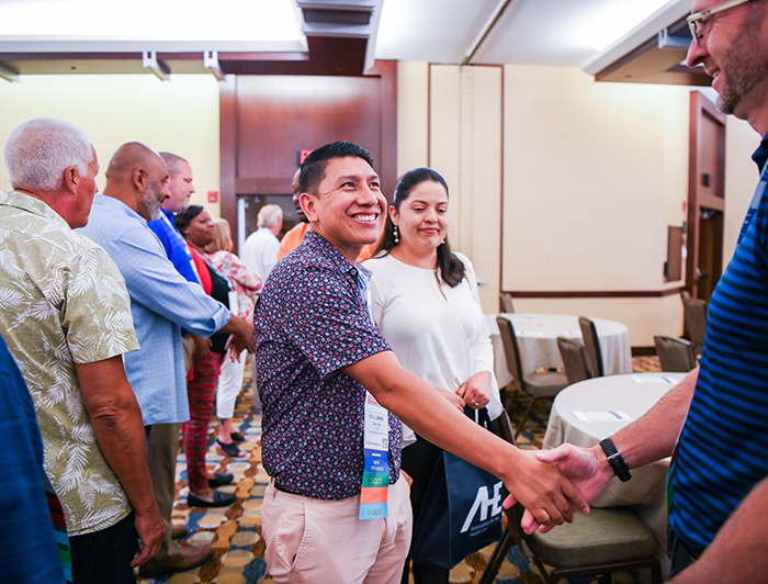 new member shaking hands with AHE Advisory Board at Exchange Conference