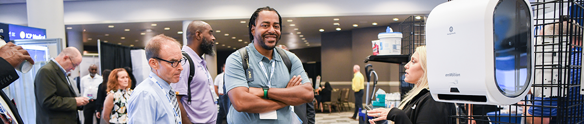 Exchange Conference attendees talking with a solution exhibitor