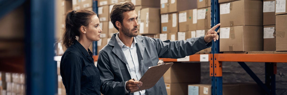 woman in scrubs making a hospital bed in a hospital room